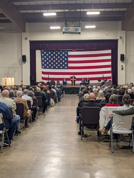 Preaching to a large crowd in a meeting hall