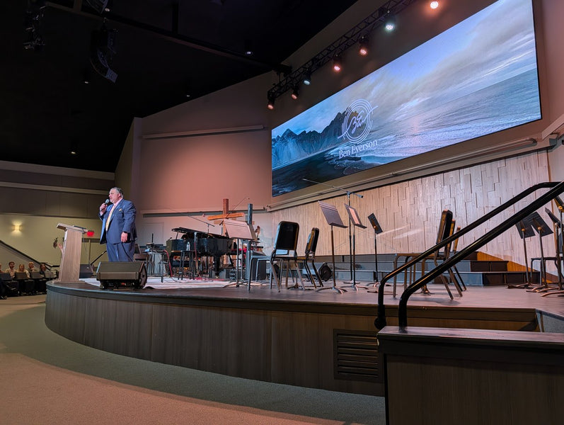 Ministering in a modern auditorium with a large video wall